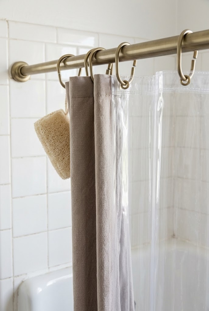 Matte metal curtain rings and a hemmed liner on a rental shower rod