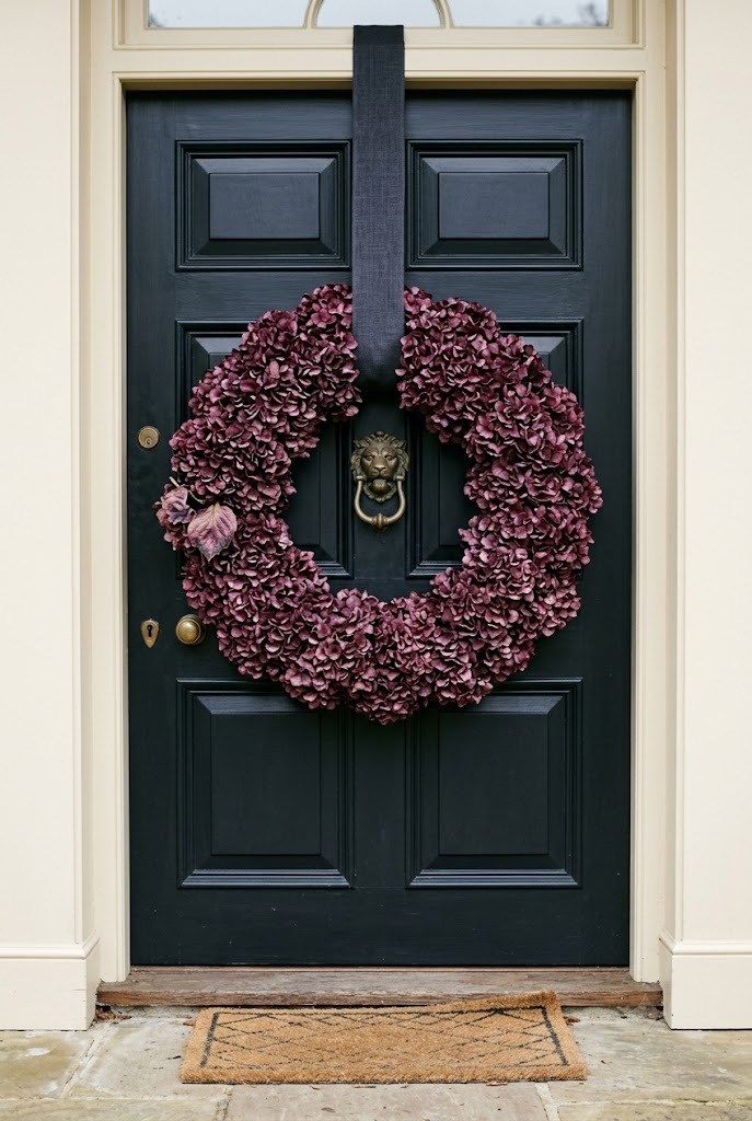 Full plum dried hydrangea wreath on a dark front door, no orange fall decor