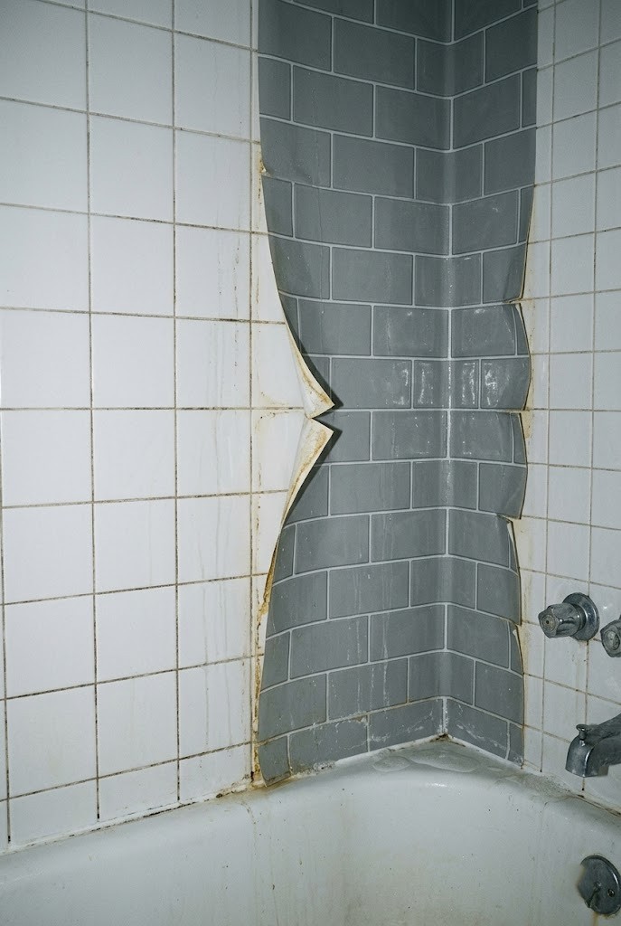 Peel-and-stick tile failing on a wet rental tub surround